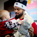 Kyle Van Noy giving a gift to a child